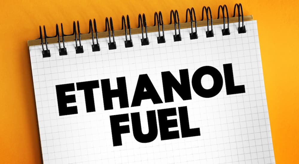 A notebook that says 'ethanol fuel' is shown at a used car dealership.