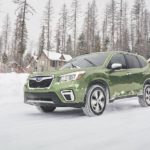 A green 2019 Subaru Forester is shown driving in snow.
