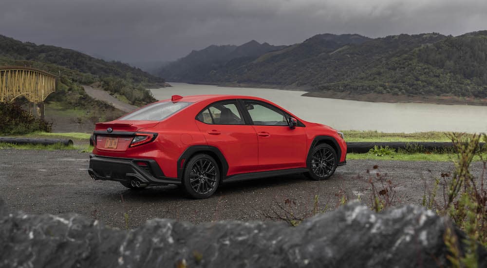 A red 2022 Subaru WRX is shown from the rear at an angle near a river after leaving a Subaru dealership.