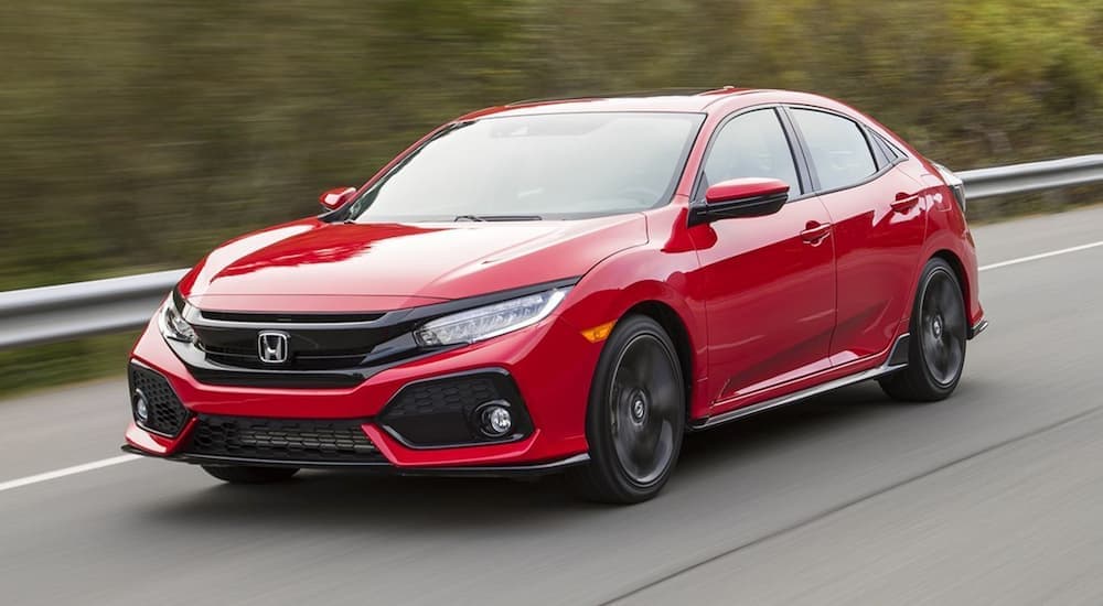 A popular cheap car for sale, a red 2017 Honda Civic, is shown driving on an open road.