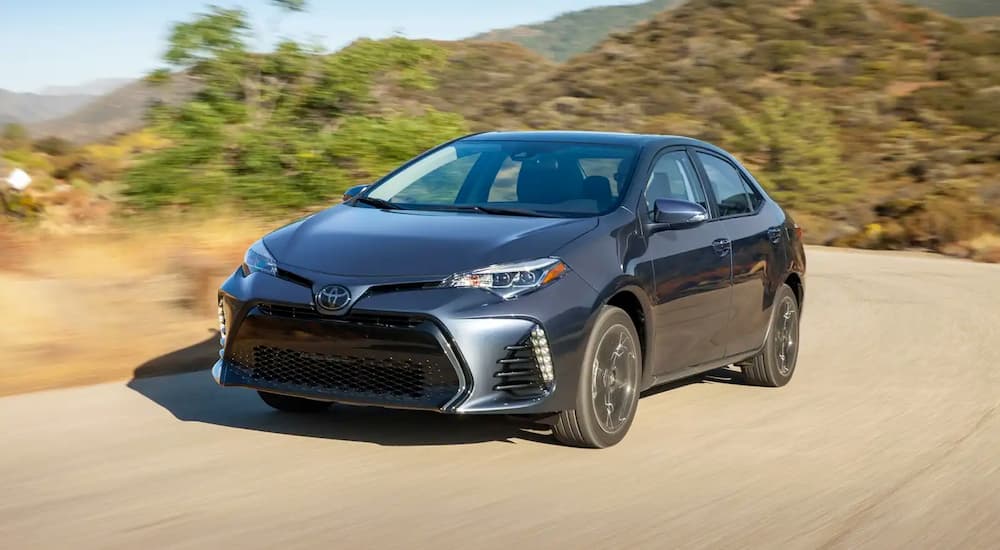 A grey 2018 Toyota Corolla is shown driving on an open road.