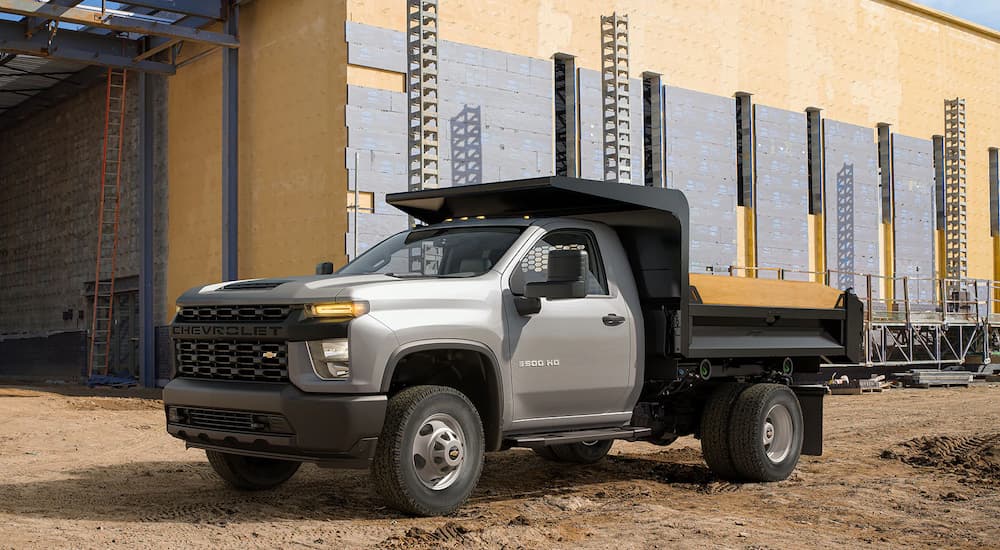 A gray 2022 Chevrolet Silverado 3500 service truck is shown at a construction site.