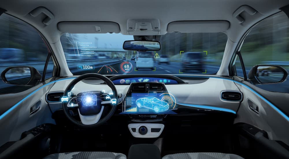 The interior of a car is shown simulating a self-driving scenario.