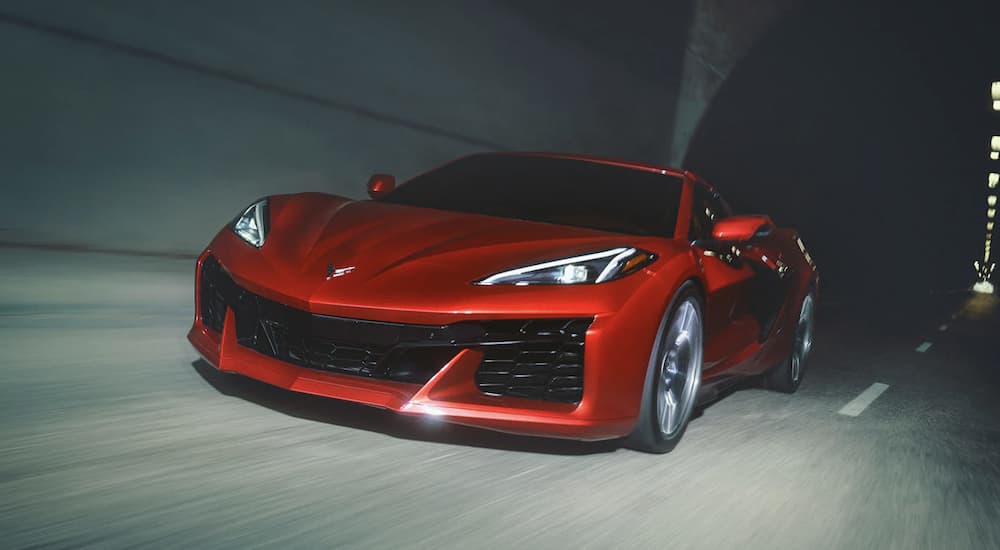 A red 2023 Corvette Z06 is shown driving through a tunnel.