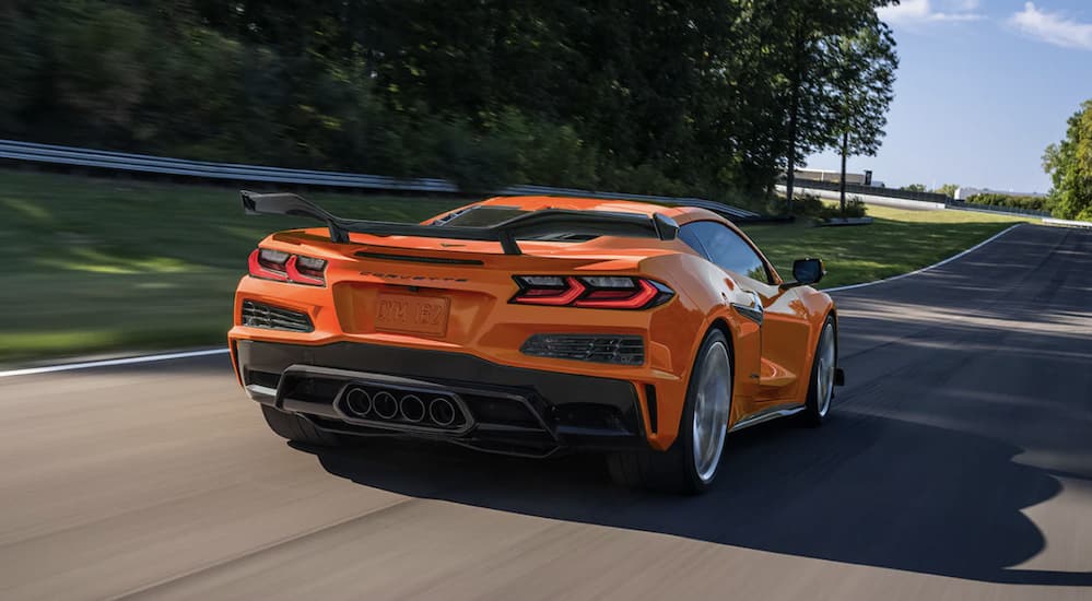 A orange 2023 Corvette Z06 is shown from the rear driving to look at a used Chevrolet.