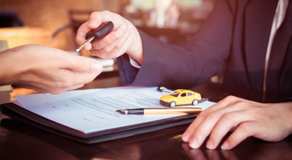 A salesman and customer are shown going over paperwork to value their trade.