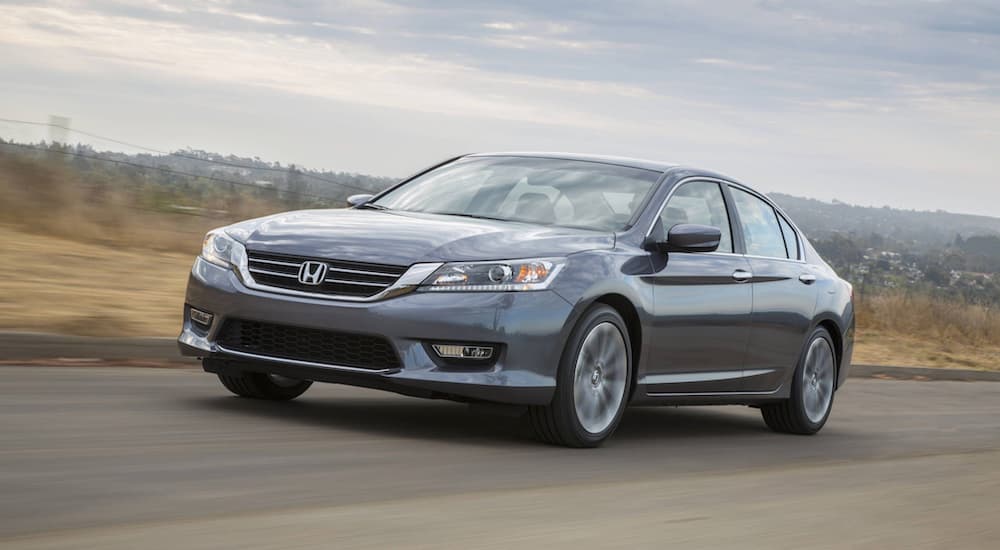 A grey 2015 Honda Accord is shown from the front at an angle after leaving a dealer that had a Honda Accord for sale.