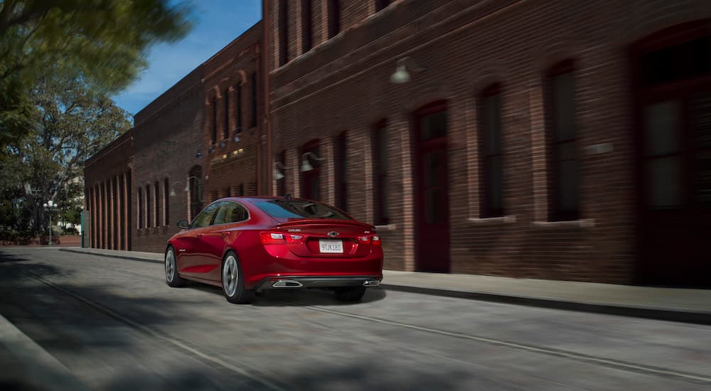 A red 2023 Chevy Malibu is shown from the rear at an angle.