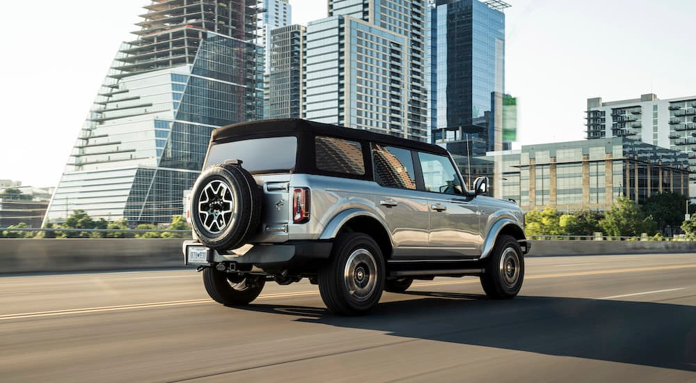 A silver 2021 Ford Bronco Outer Banks is shown from the rear at an angle.