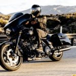 A man is shown on a 2022 Harley-Davidson Street Glide driving on an open road.