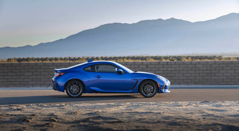 A blue 2022 Subaru BRZ is shown from the side in front of distant mountains.