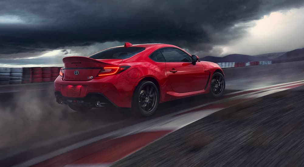 A red 2022 Toyota GR86 is shown from the side driving on a racetrack.