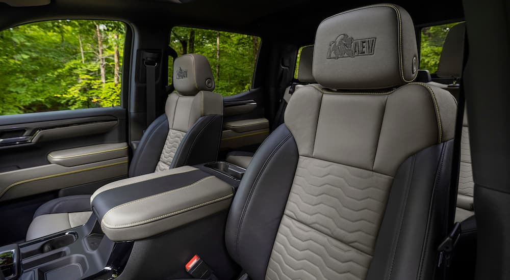 The black and tan interior of a 2023 Chevy Silverado 1500 ZR2 Bison is shown from the drivers seat facing backwards.