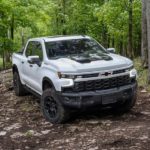 A white 2023 Chevy Silverado 1500 ZR2 Bison is shown from the front at amn angle while parked off-road.