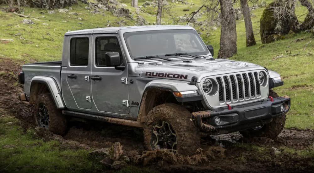 A silver 2023 Jeep Gladiator is shown off-roading.