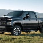 A black 2023 Chevy Silverado 2500HD is shown parked in a field.