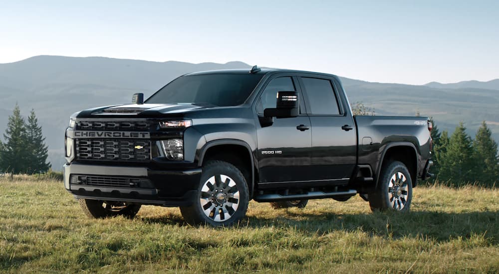 A black 2023 Chevy Silverado 2500HD is shown parked in a field.