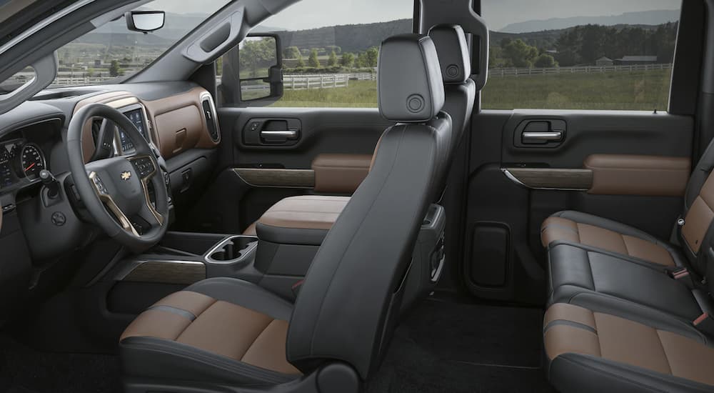 The black and brown interior of a 2023 Chevy Silverado 3500HD shows two rows of seating.
