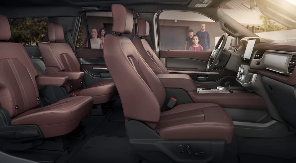 The brown interior of a 2023 Ford Expedition shows two rows of seating.