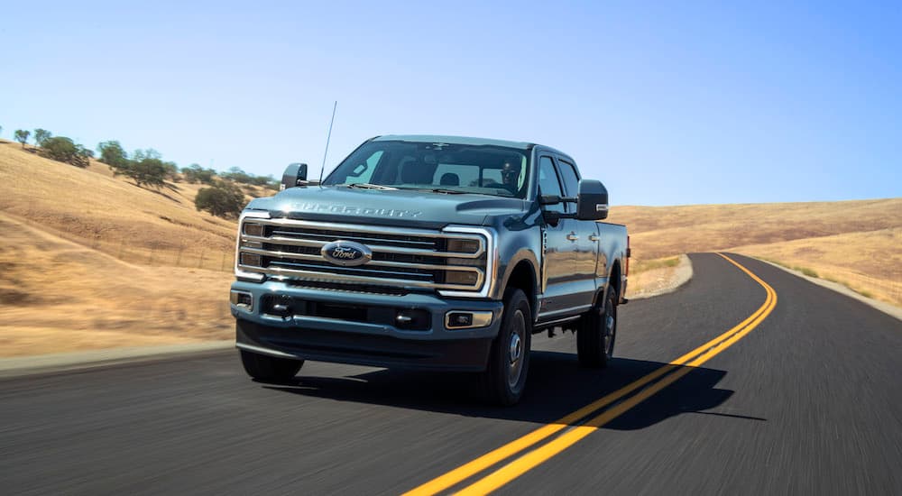 A blue 2023 Ford F-350 Super Duty is shown from the front while driving.