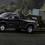 A black 2023 GMC Sierra 3500 HD is shown towing a trailer.