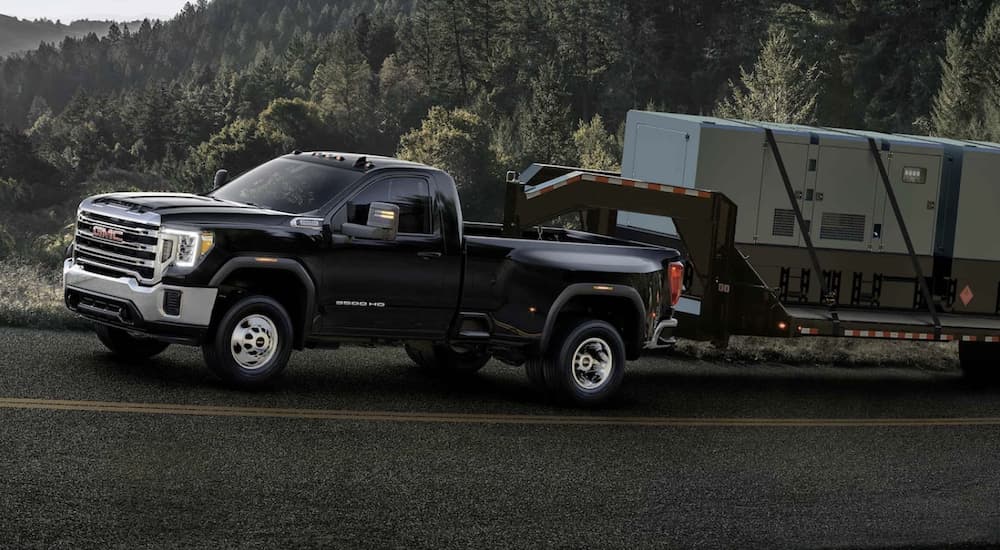 A black 2023 GMC Sierra 3500 HD is shown towing a trailer.