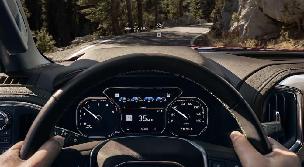 The black interior of a 2023 GMC Sierra 3500 HD shows the steering wheel in close up.