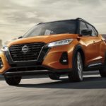 An orange 2023 Nissan Kicks is shown leaving the city.