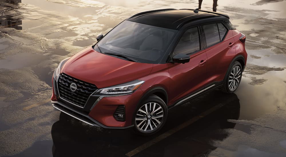 A red 2023 Nissan Kicks is shown parked on a beach.