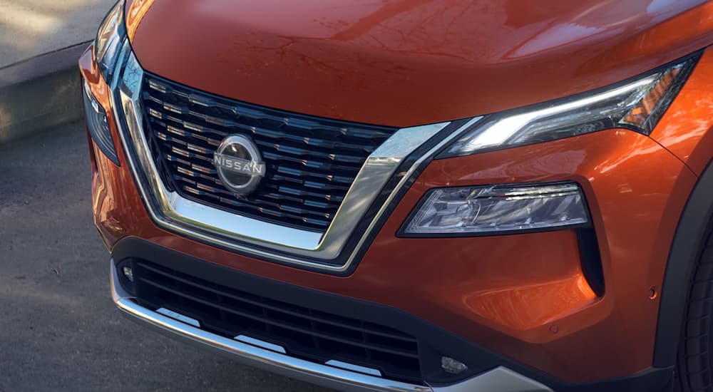 A close up of the grille of an orange 2023 Nissan Rogue is shown.