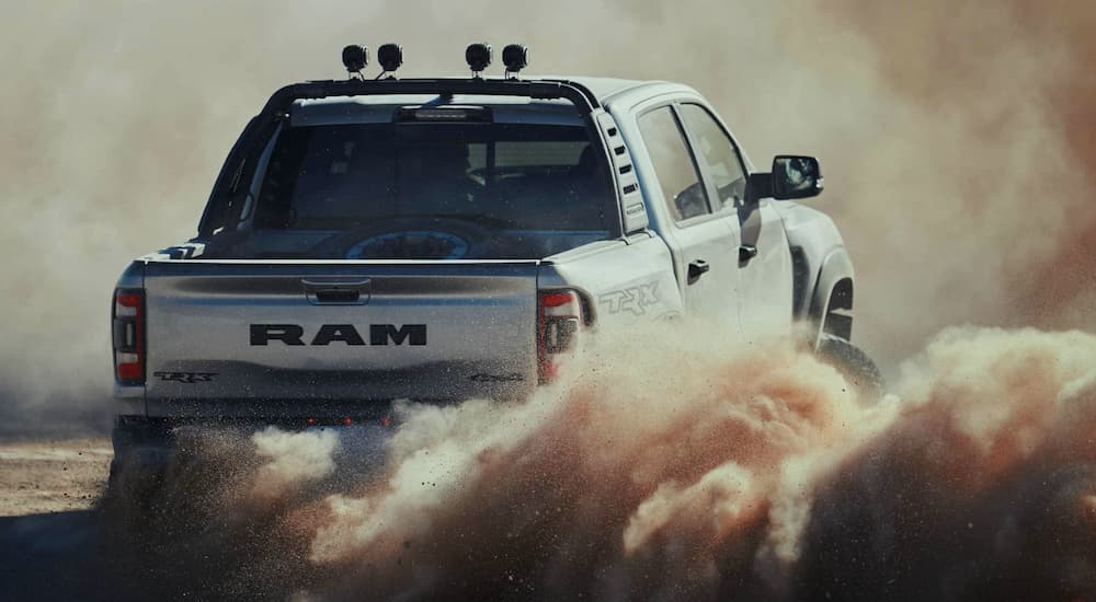 A grey 2023 Ram 1500 TRX is shown kicking up dirt.