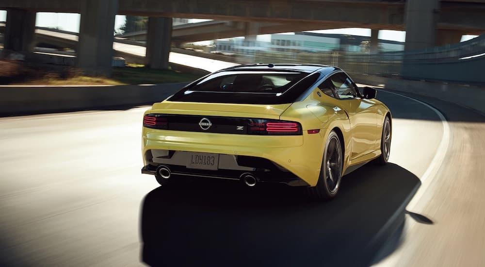 A yellow 2023 Nissan Z is shown from the rear at an angle after leaving a Nissan dealer.