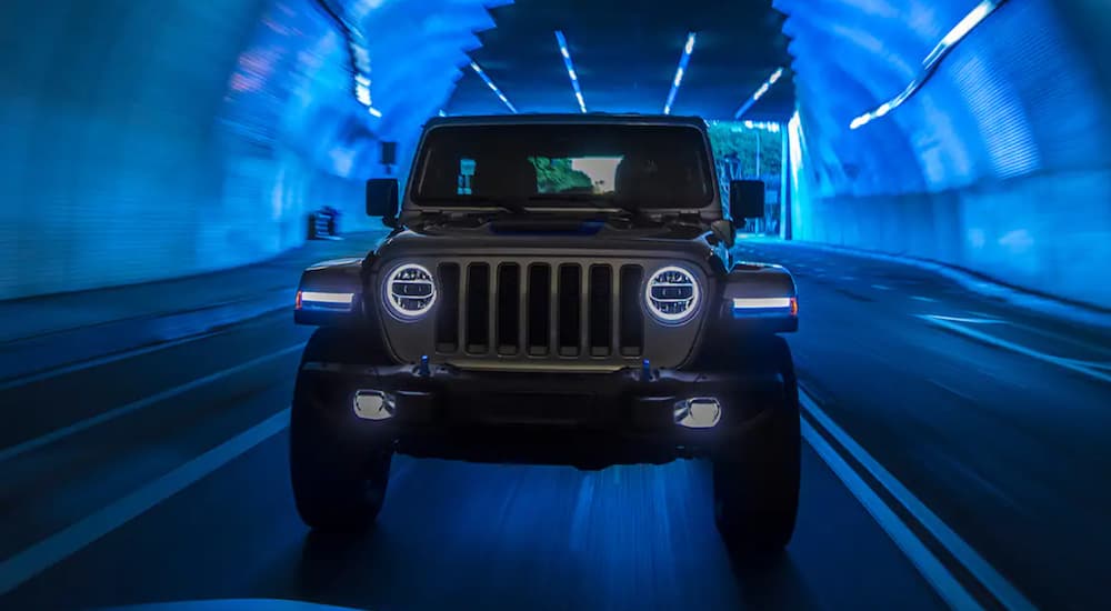 A gray 2021 Jeep Wrangler 4xe is shown driving through a tunnel.