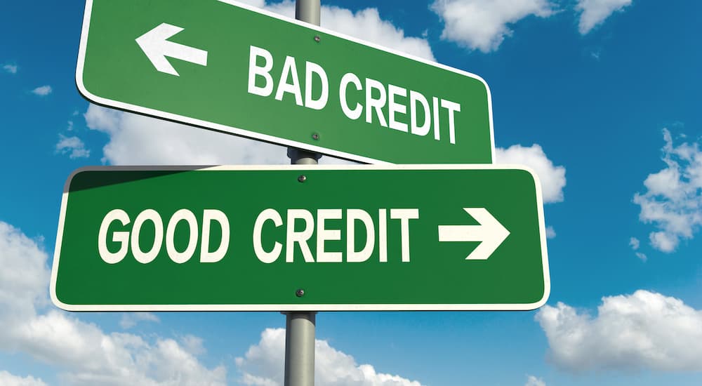 A set of green signs are shown with the words 'good credit' and 'bad credit.'