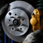 Crucial for any cars for sale, a close-up is shown of a mechanic working on a brake.
