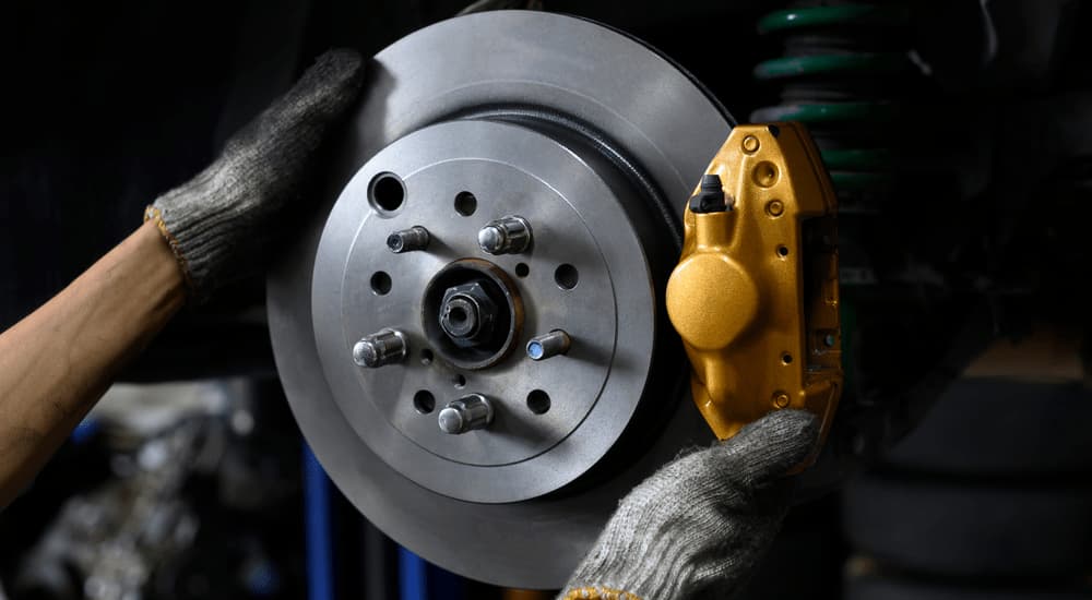 Crucial for any cars for sale, a close-up is shown of a mechanic working on a brake.