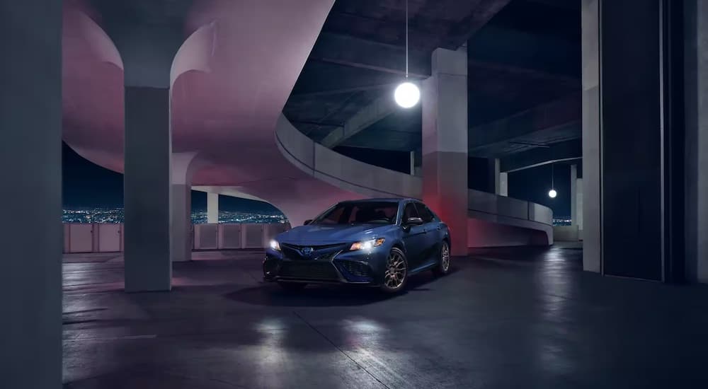 A blue 2023 Toyota Camry Nightshade is shown from the front at an angle in a parking garage after leaving a dealer that had a Toyota Camry for sale.