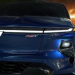 A close up of the front of a blue 2024 Chevy Silverado EV RST is shown at a Chevy truck dealer.