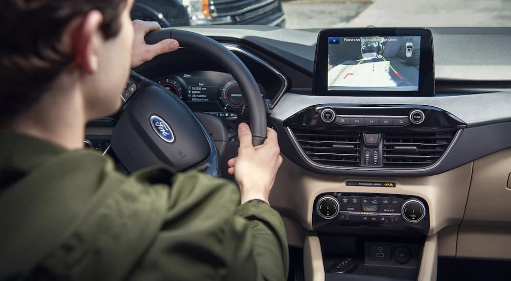 A person is shown viewing the back-up camera in a 2022 Ford Escape.