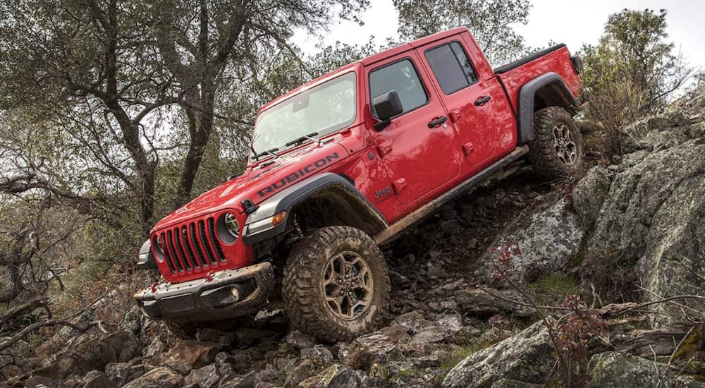 A red 2021 Jeep Gladiator is shown off-roading.