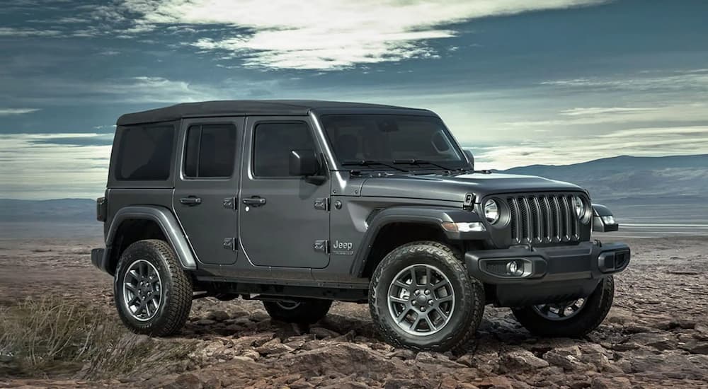A popular Fuel efficient used car for sale, a grey 2021 Jeep Wrangler, is shown from the side.