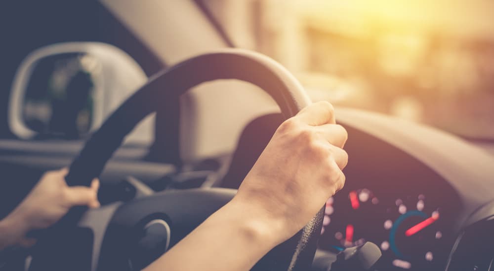 A person is shown driving to a GMC dealer.