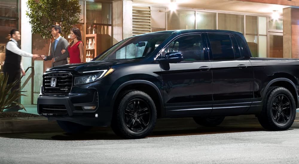 A black 2023 Honda Ridgeline Black Edition is shown from the side parked on a city street.