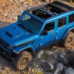 A blue 2022 Jeep Wrangler Rubicon 392 is shown on a rocky path after leaving a Jeep Wrangler dealer.