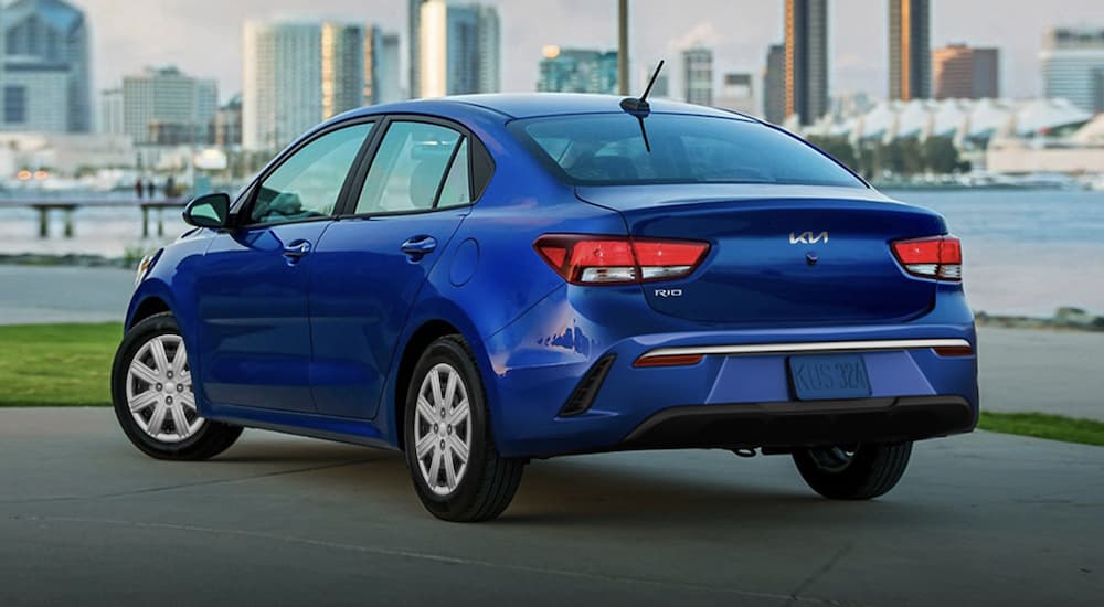 A blue 2023 Kia Rio is shown from the rear.