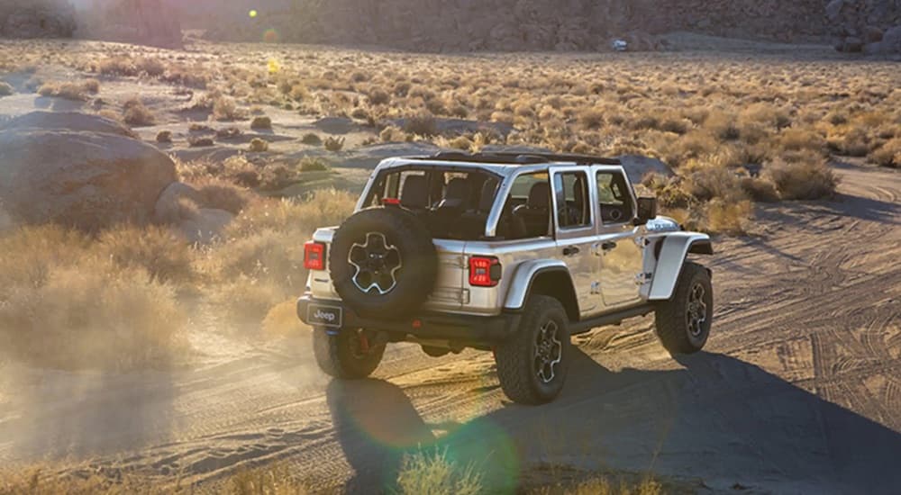 A silver 2023 Jeep Wrangler 4xe is shown from the rear at an angle.