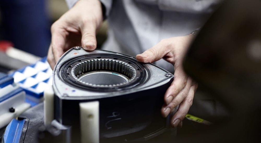 A person is shown holding a engine rotor.