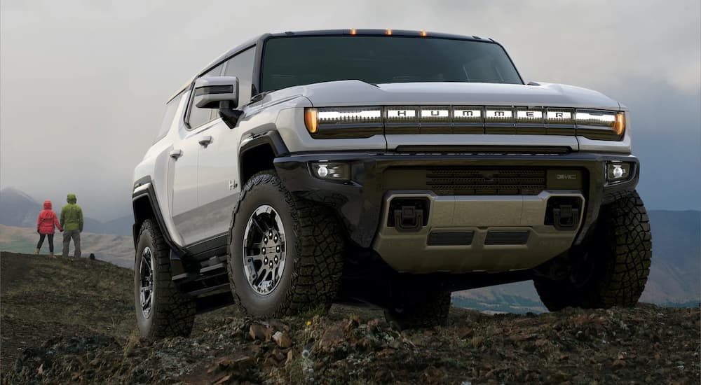 A white 2022 GMC Hummer EV is shown parked on top of a mountain.