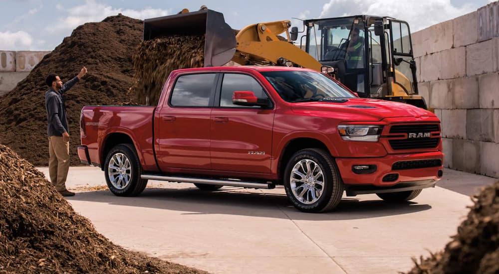 A red 2021 Ram 1500 is shown parked after leaving a truck dealership.