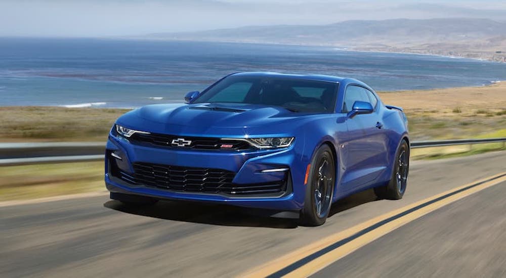 A popular used Chevy for sale, blue 2020 Chevy Camaro SS, is shown driving on a open road.